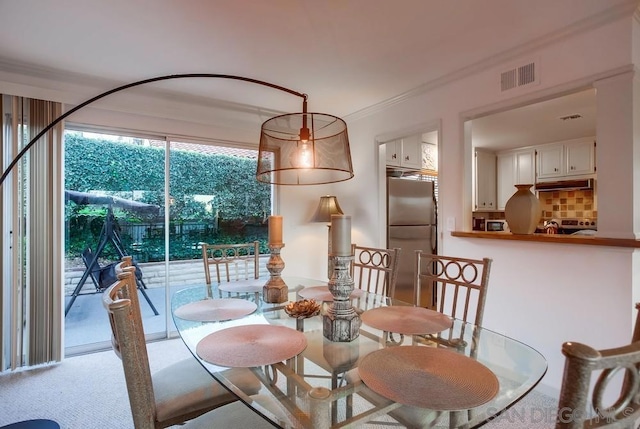 dining area with ornamental molding and carpet floors