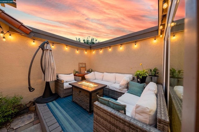 patio terrace at dusk featuring an outdoor living space with a fire pit