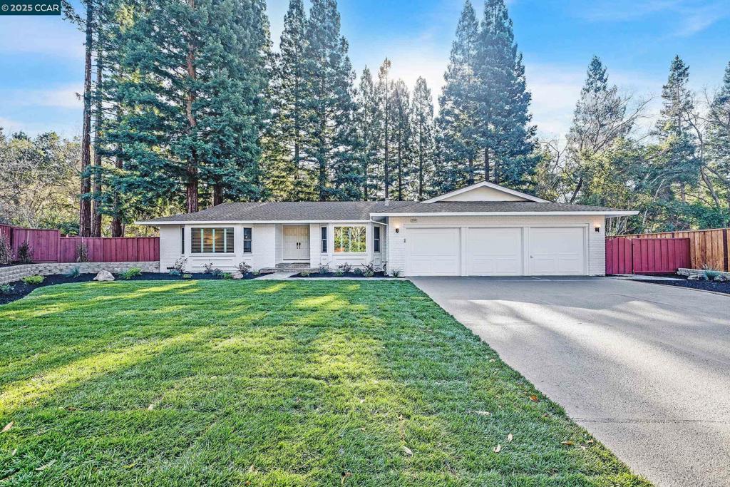 ranch-style house featuring a front yard and a garage