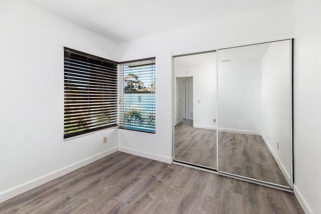 unfurnished bedroom with a closet and wood-type flooring