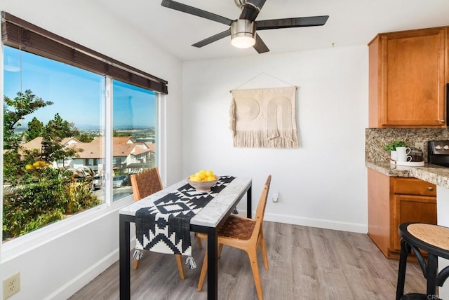 dining space with ceiling fan and light hardwood / wood-style floors