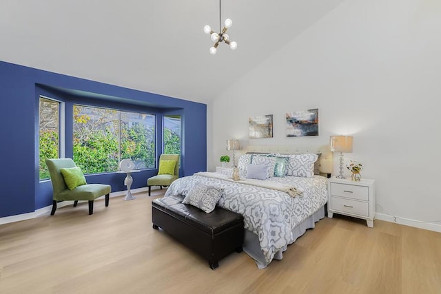 bedroom featuring a notable chandelier, light hardwood / wood-style flooring, and high vaulted ceiling