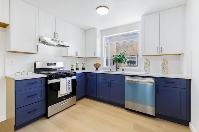 kitchen with light hardwood / wood-style flooring, white cabinetry, blue cabinets, appliances with stainless steel finishes, and sink