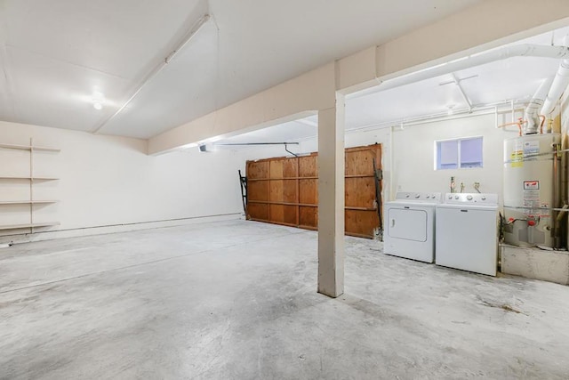 garage with water heater and washer and clothes dryer