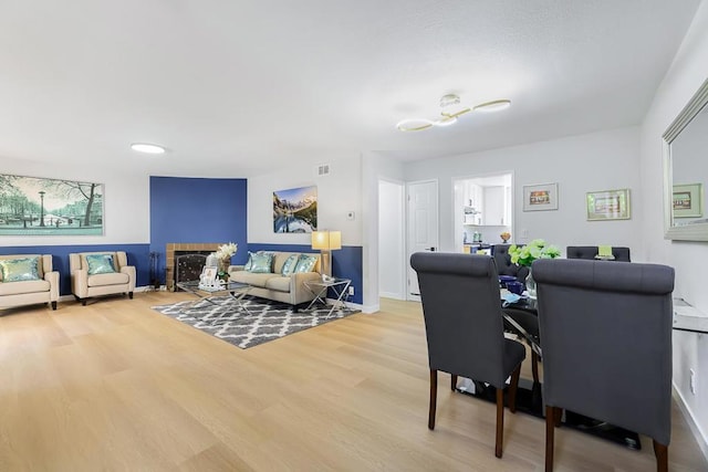 dining space featuring a brick fireplace and hardwood / wood-style flooring