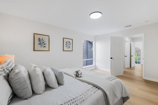 bedroom featuring multiple windows and light hardwood / wood-style flooring