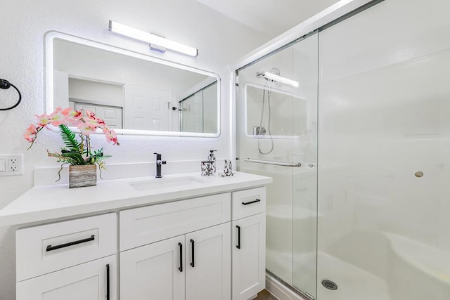 bathroom with a shower with door and vanity