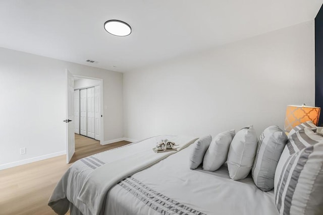 bedroom with light wood-type flooring and a closet