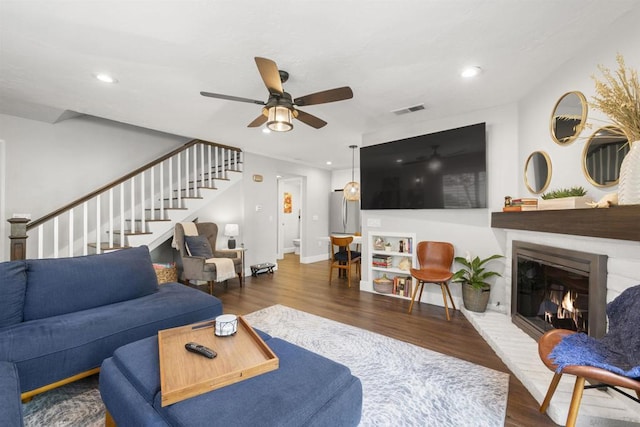 living room with ceiling fan and dark hardwood / wood-style flooring