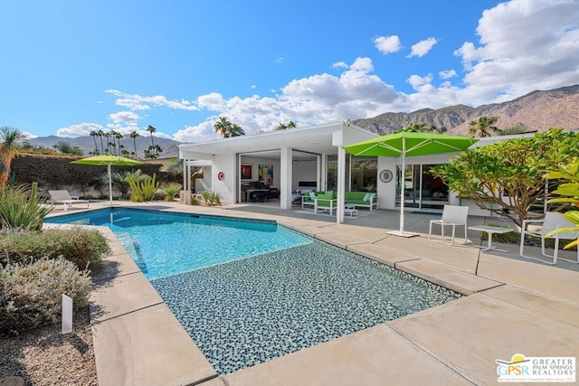 view of pool with a patio and a mountain view