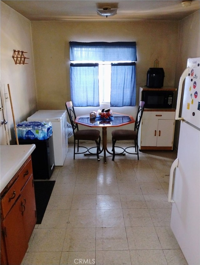 kitchen with white refrigerator and white cabinetry