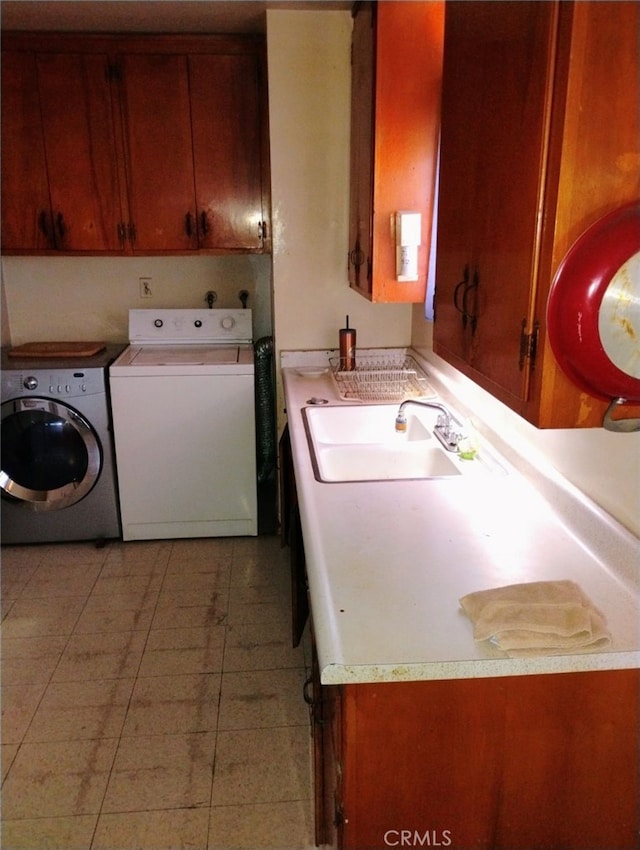 washroom with cabinets, washing machine and clothes dryer, and sink