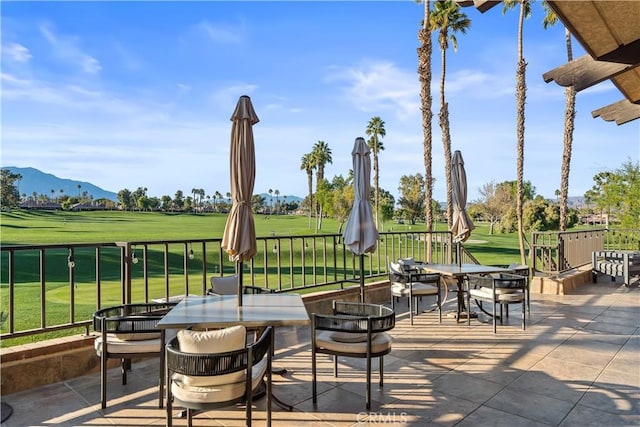 view of patio / terrace featuring outdoor dining space, fence, and a mountain view