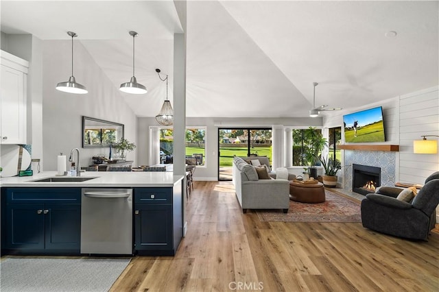 kitchen with open floor plan, dishwasher, a peninsula, and a sink