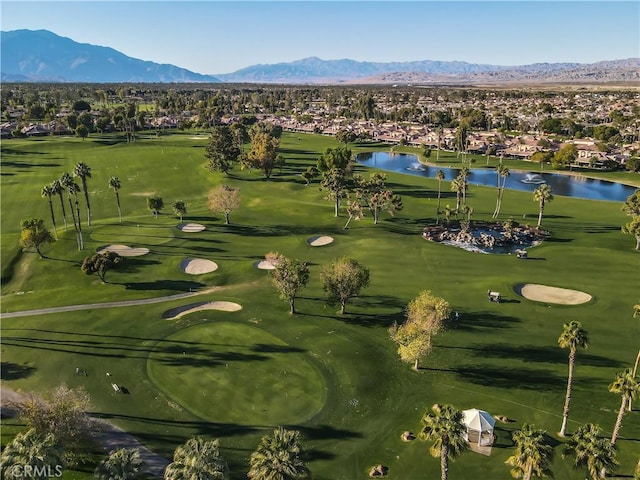 birds eye view of property with view of golf course and a water and mountain view