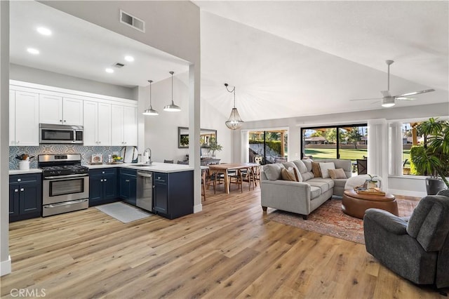 kitchen featuring open floor plan, appliances with stainless steel finishes, visible vents, and white cabinetry