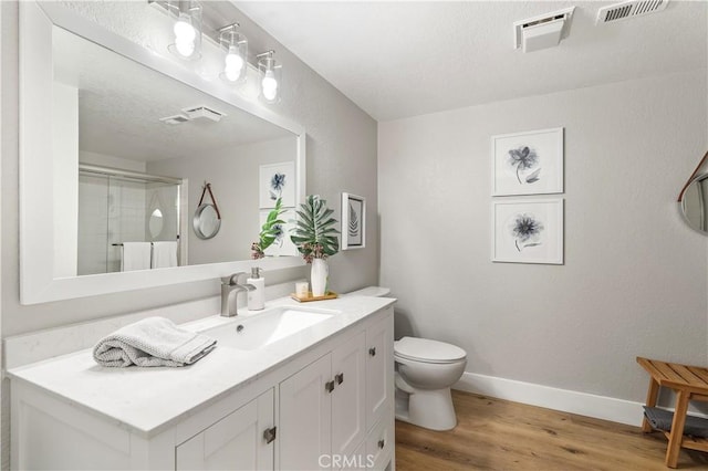 full bathroom featuring wood finished floors, an enclosed shower, visible vents, and baseboards