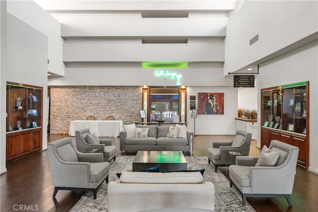 living room featuring dark wood-style floors, visible vents, and a high ceiling