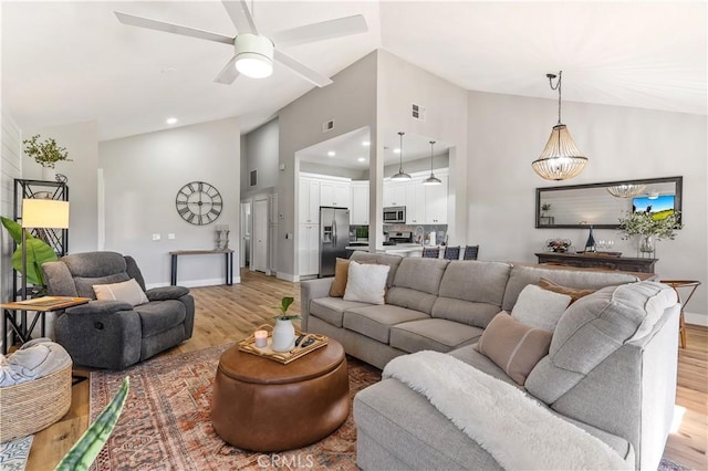 living area featuring visible vents, baseboards, ceiling fan with notable chandelier, light wood-style floors, and recessed lighting