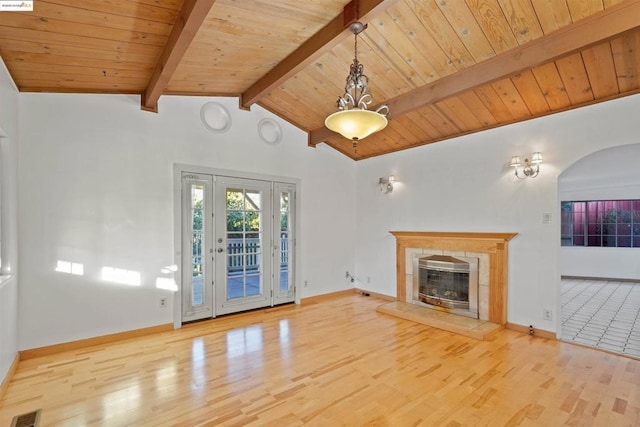 unfurnished living room featuring wood ceiling, light hardwood / wood-style flooring, lofted ceiling with beams, and a tile fireplace