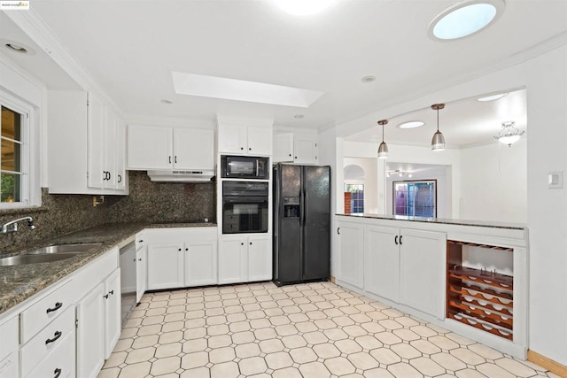 kitchen with pendant lighting, sink, white cabinetry, a skylight, and black appliances