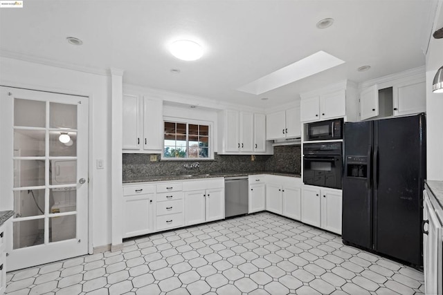 kitchen with a skylight, white cabinetry, sink, decorative backsplash, and black appliances