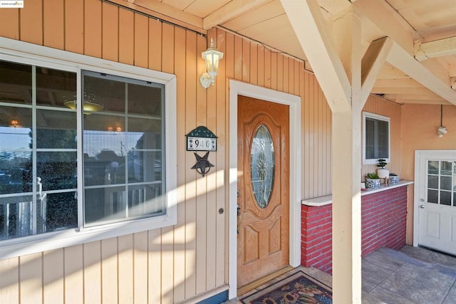 view of exterior entry featuring covered porch