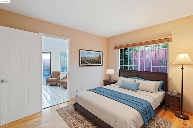 bedroom with multiple windows and light hardwood / wood-style flooring