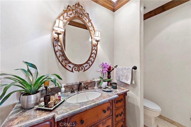 bathroom featuring toilet, vanity, and crown molding