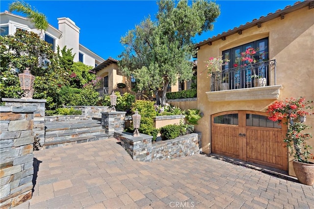 view of patio featuring a balcony and a garage