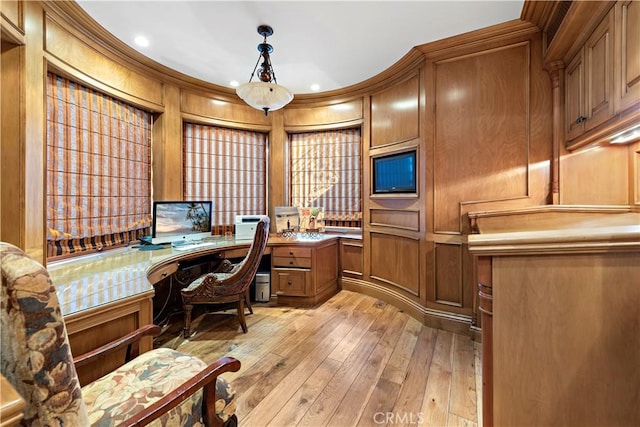 office space featuring wood walls, light hardwood / wood-style floors, and crown molding