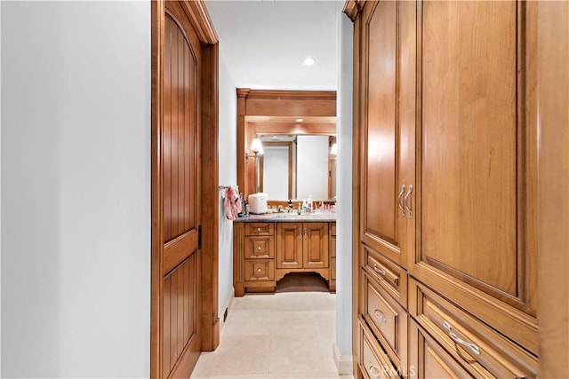 corridor featuring sink and light tile patterned floors