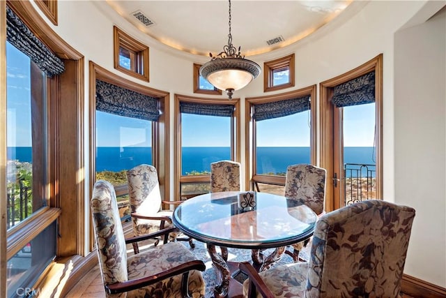 dining space featuring wood-type flooring and a water view