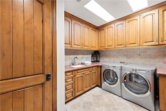 laundry room featuring cabinets, washer and clothes dryer, and sink