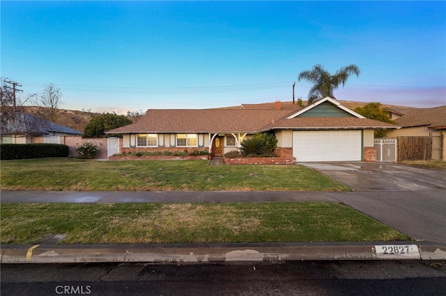 ranch-style house with a yard and a garage