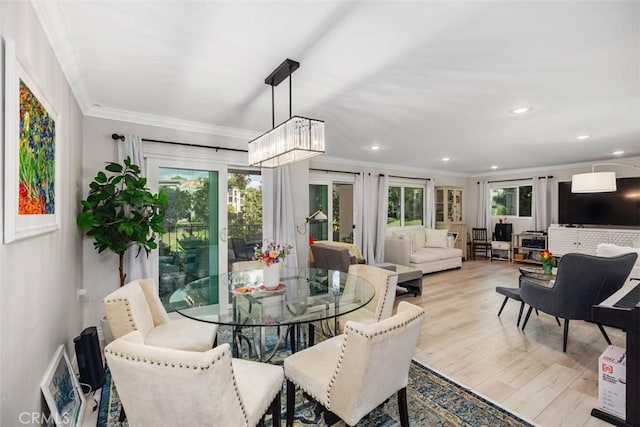 dining room featuring ornamental molding, a notable chandelier, and light hardwood / wood-style flooring