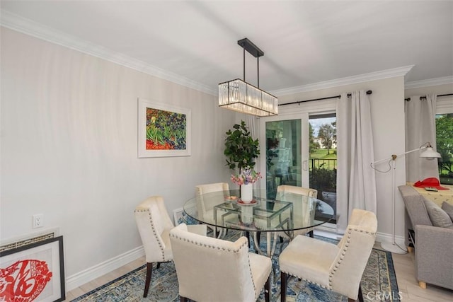 dining space with ornamental molding, light hardwood / wood-style flooring, and a chandelier