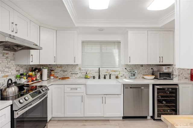 kitchen with beverage cooler, appliances with stainless steel finishes, and white cabinetry