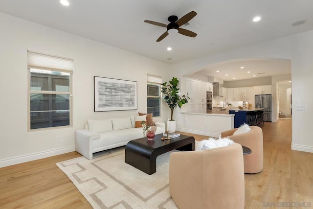 living room with light hardwood / wood-style floors and ceiling fan