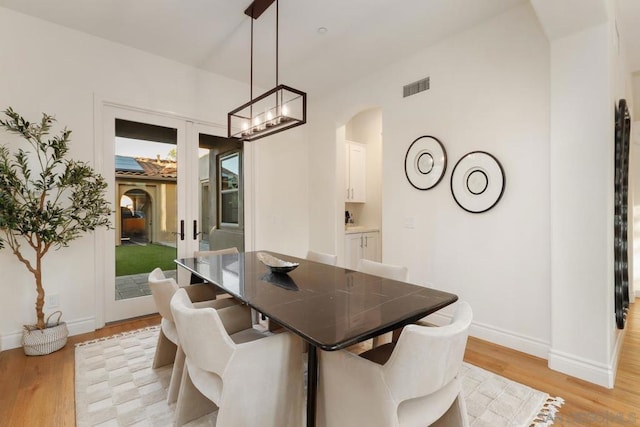 dining space featuring french doors and light hardwood / wood-style flooring