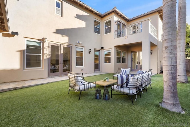 back of house featuring french doors, a lawn, and an outdoor living space