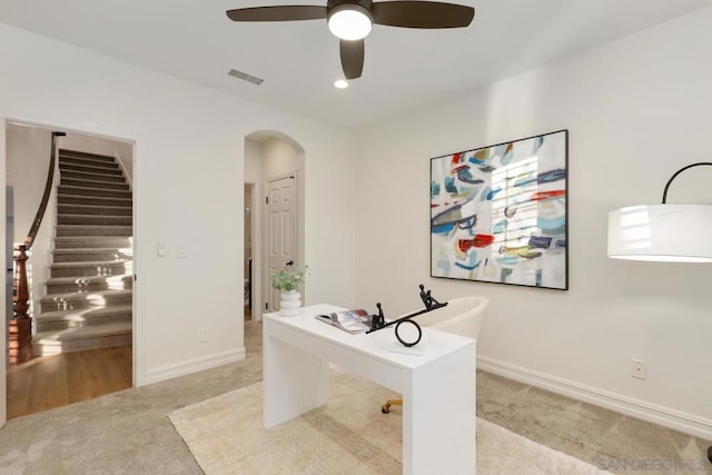 carpeted office space featuring ceiling fan