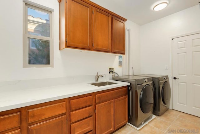 washroom with cabinets, light tile patterned flooring, washer and clothes dryer, and sink