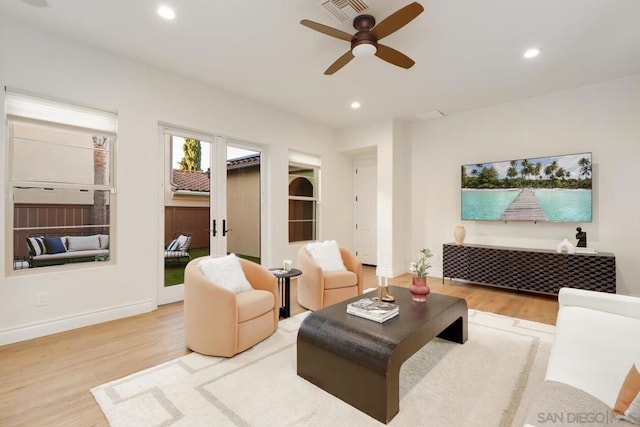 living room featuring light hardwood / wood-style floors and ceiling fan