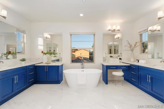 bathroom with a wealth of natural light, vanity, and a bathing tub