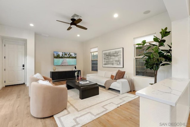 living room featuring ceiling fan and light hardwood / wood-style floors