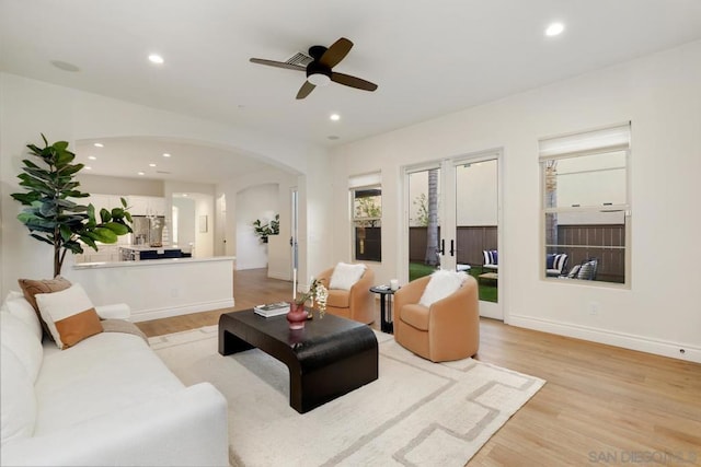 living room with ceiling fan and light wood-type flooring