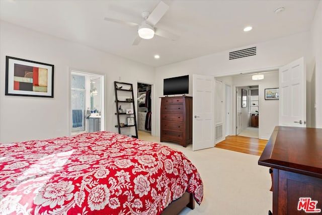 carpeted bedroom with ensuite bathroom and ceiling fan