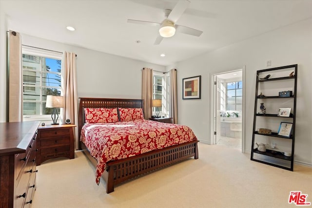 bedroom featuring ceiling fan, light carpet, and ensuite bath