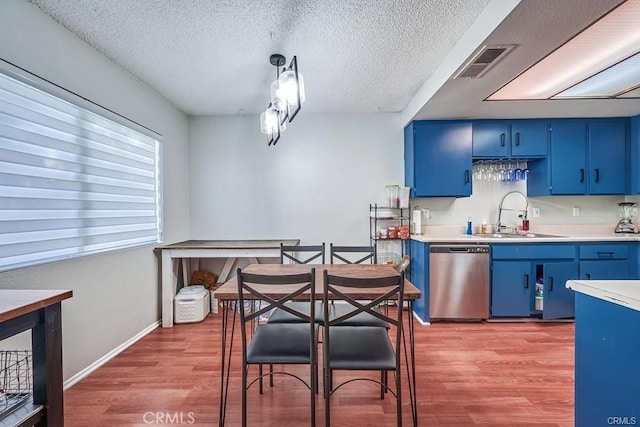 kitchen featuring hardwood / wood-style flooring, sink, stainless steel dishwasher, and blue cabinetry